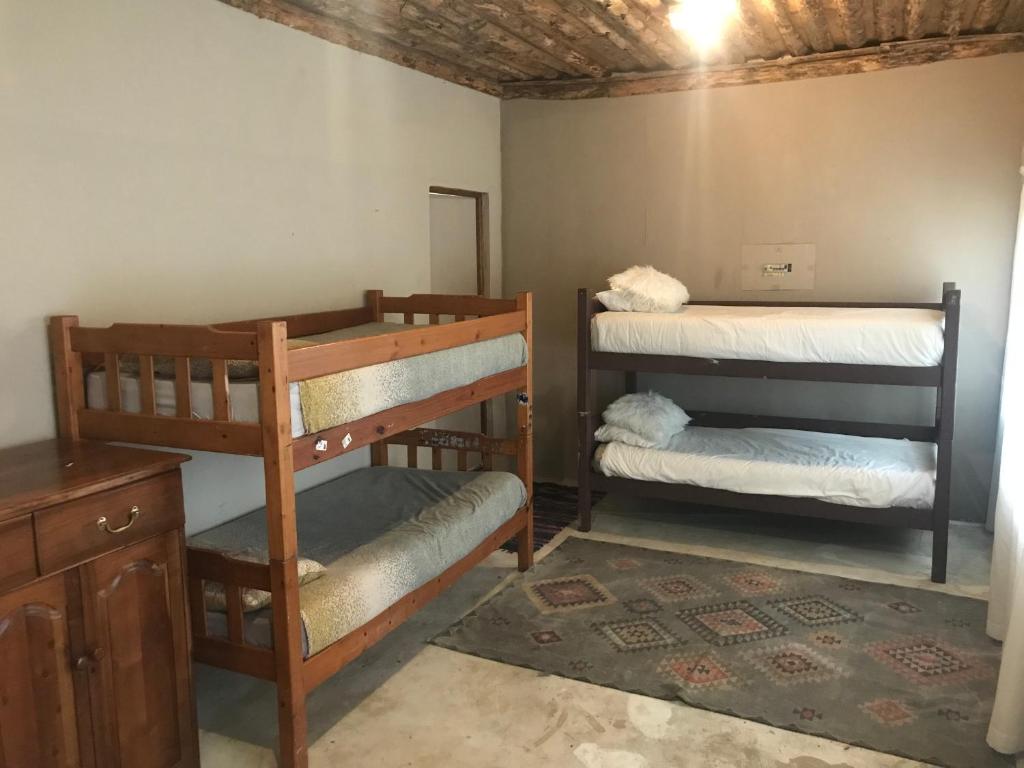 a room with two bunk beds and a desk at Dullstroom on the Dam Backpackers in Dullstroom