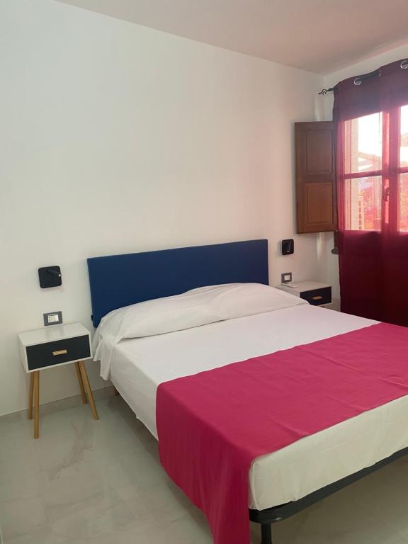 een slaapkamer met een groot bed met een rode en witte deken bij Oriente Rooms in San Nicola Arcella