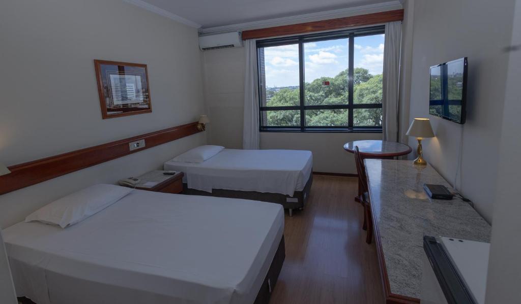 Cama ou camas em um quarto em Lizon Curitiba Hotel