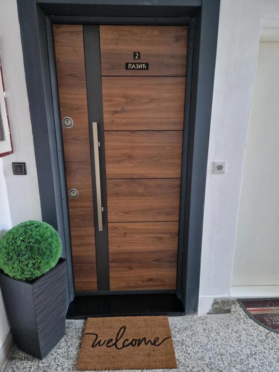 a wooden door with a welcome sign on it at Stan na dan Jelica Stanivuković in Šid