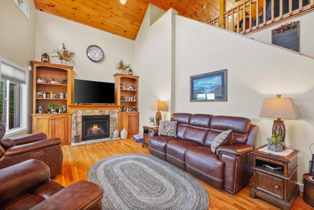 uma sala de estar com mobiliário de couro e uma lareira em Luxury Douglas Lake Chalet - Great Location! em Dandridge