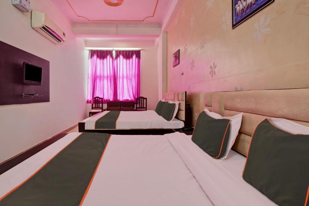 a room with two beds and a couch and a window at Tiger View Hotel in Sawāi Mādhopur