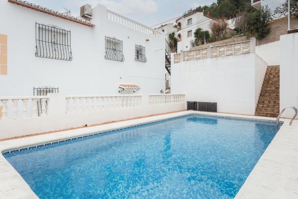 una piscina frente a un edificio blanco en Maison Oliva 2, en La Font D´En Carròs