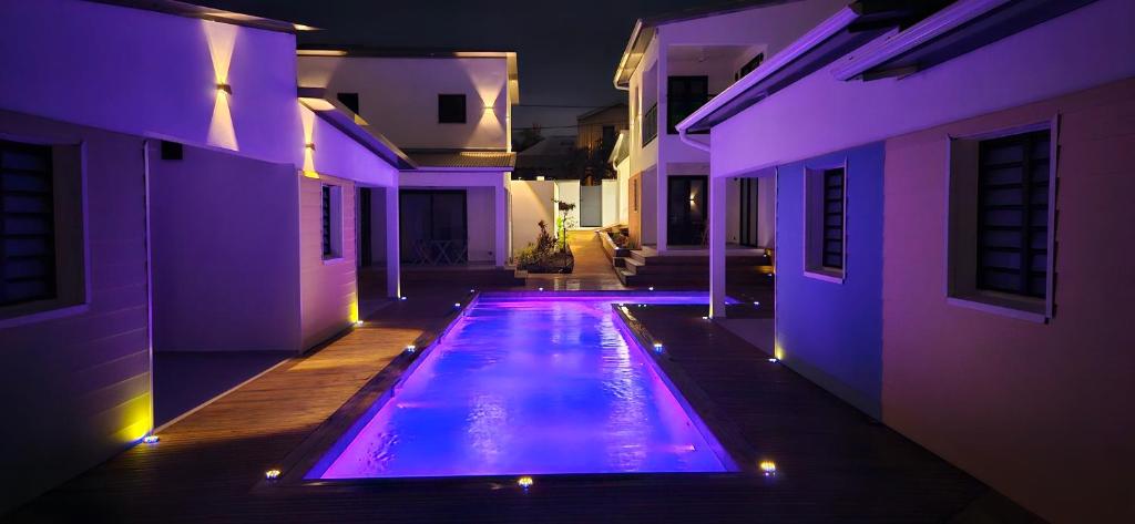 a swimming pool with purple lights in a house at Paradise City Break in Saint-Pierre