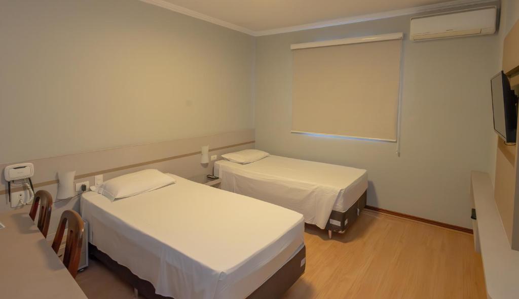 Cama ou camas em um quarto em Lizon Curitiba Hotel