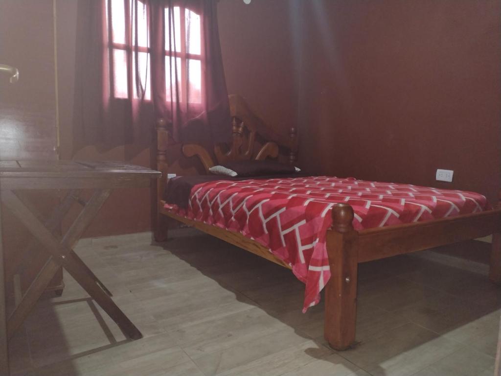 a bed in a room with a table and a window at Cabañas Viltez in Tafí del Valle