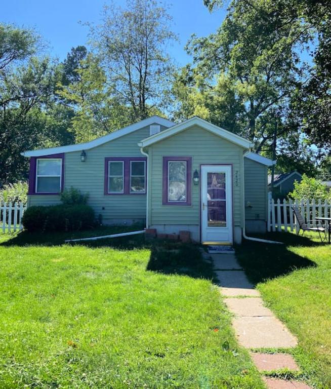 a small green house with a white fence at Quiet 1 Bedroom in Rock Island, IL. in Rock Island