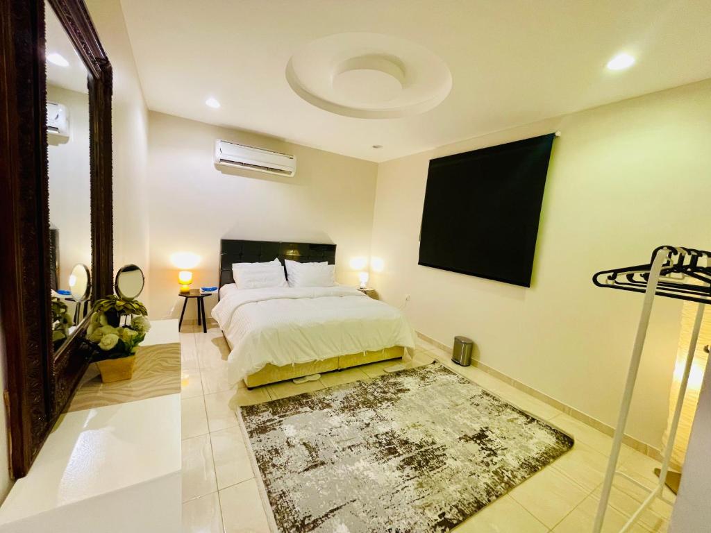 Haven في مكة المكرمة: غرفة نوم مع سرير وتلفزيون على الحائط