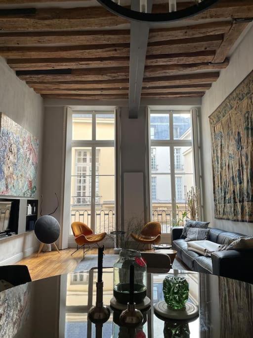 un salon avec un canapé et une table dans l'établissement Golden Braque: luxury meet history, à Paris