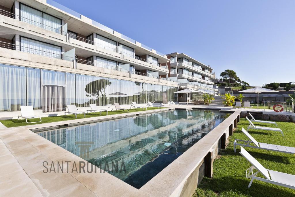 una piscina di fronte a un edificio di Santa Romana Apartments & Suites a Caldes d'Estrac