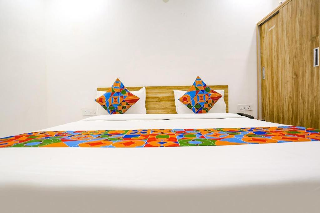 新德里的住宿－Hotel Silver Crown，一间卧室配有一张带五颜六色棉被的床
