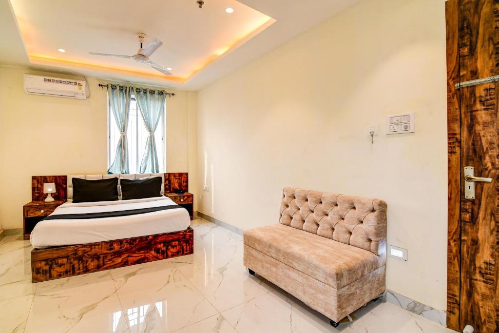 a bedroom with a bed and a chair at The Hastings Club in Kolkata