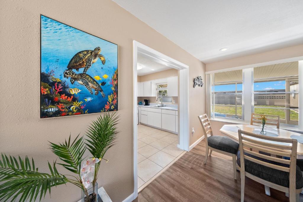 een eetkamer en een keuken met een schildpadschilderij aan de muur bij Coral Paradise near Ballard Park in Melbourne