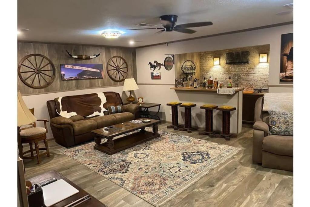 a living room with a couch and a table at StockYards! Walk 3 Blocks-Ranch House sleeps 8 in Fort Worth