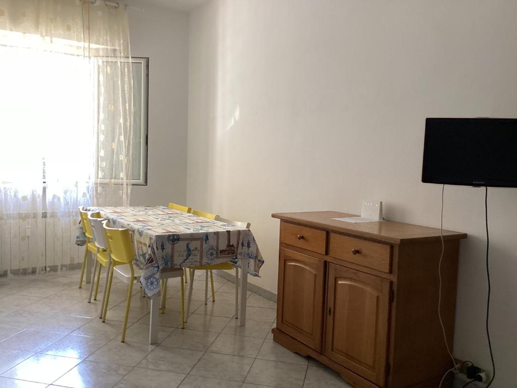 ein Esszimmer mit einem Tisch und gelben Stühlen in der Unterkunft casa mare Spotorno in Spotorno