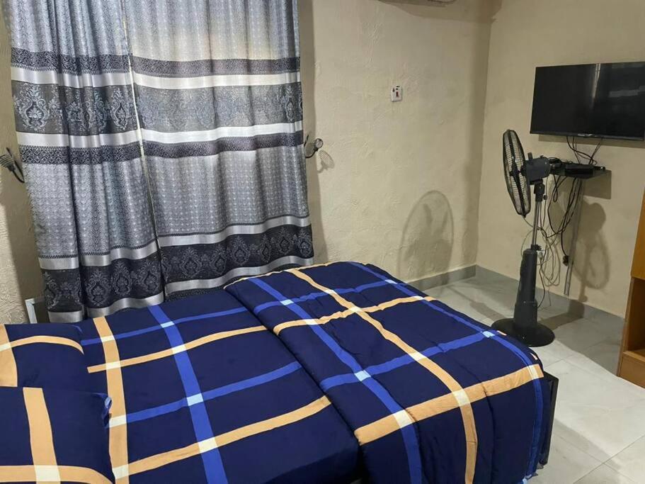a bed in a room with a curtain at 2 Bedroom and a kitchen. in Abuja