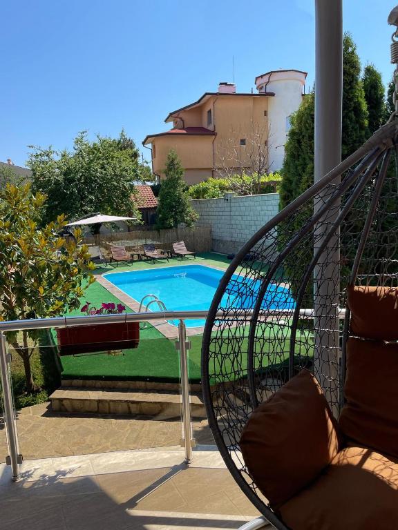 a swing on a porch with a swimming pool at Вила Фреди in Varna City