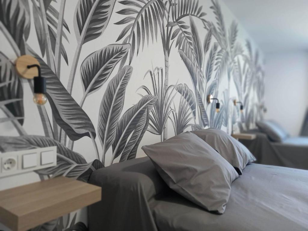 a bedroom with a wall mural of palm trees at Casa Fénix en el centro de Andalucía in La Roda de Andalucía