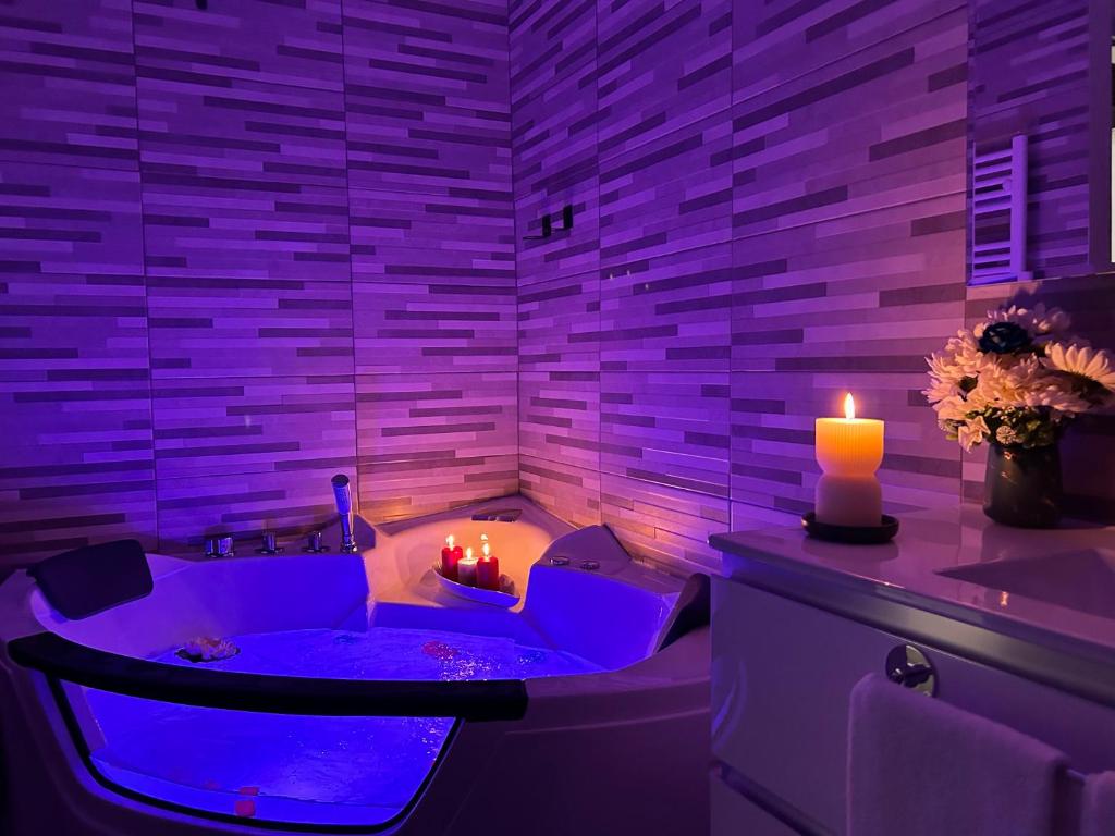baño con jacuzzi con iluminación púrpura en Suite Deluxe - Jacuzzi - Private Parking en Turín
