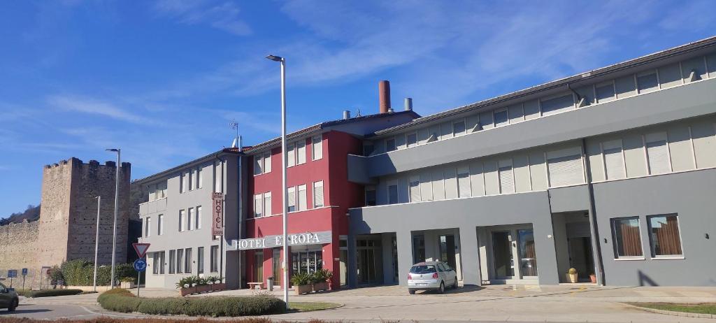 マロースティカにあるHotel Europaの駐車場付き赤白の建物