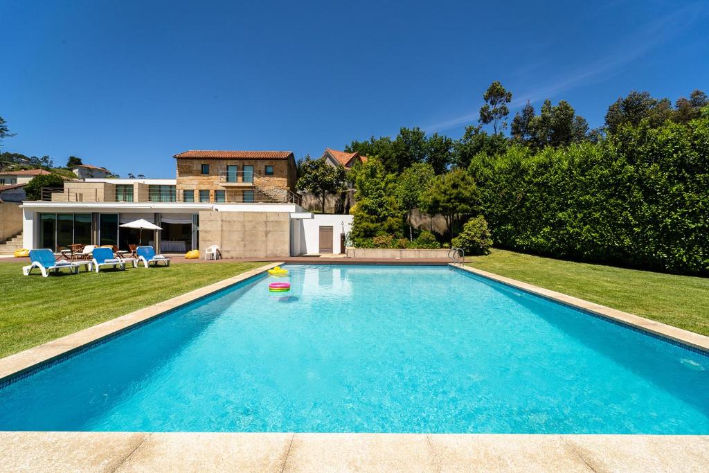 - une piscine dans l'arrière-cour d'une maison dans l'établissement Casa de Silvares Fafe - Moradia Premium com piscina by House and People, à Regadas