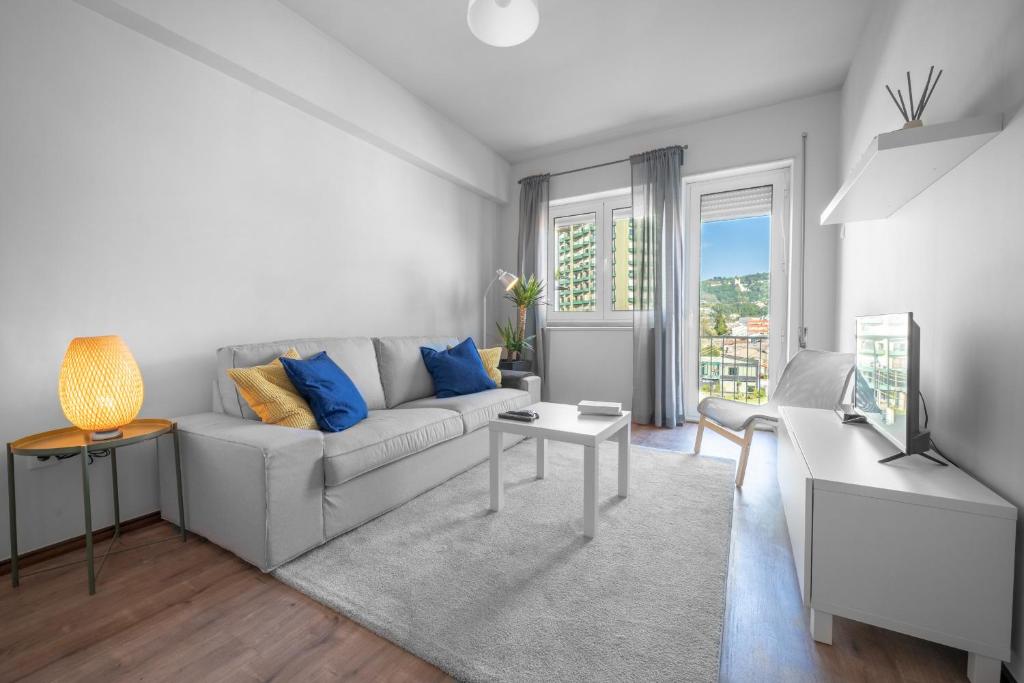 un soggiorno con divano bianco e cuscini blu di Elísio de Moura - T5 ideal para familias - Braga a Braga
