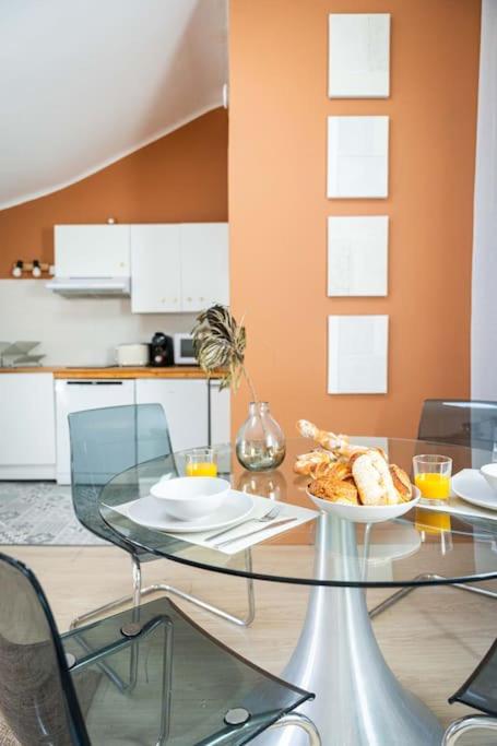 - une table en verre avec un bol de nourriture dans la cuisine dans l'établissement Studio Chaleureux niché au cœur des Salins, à Arles