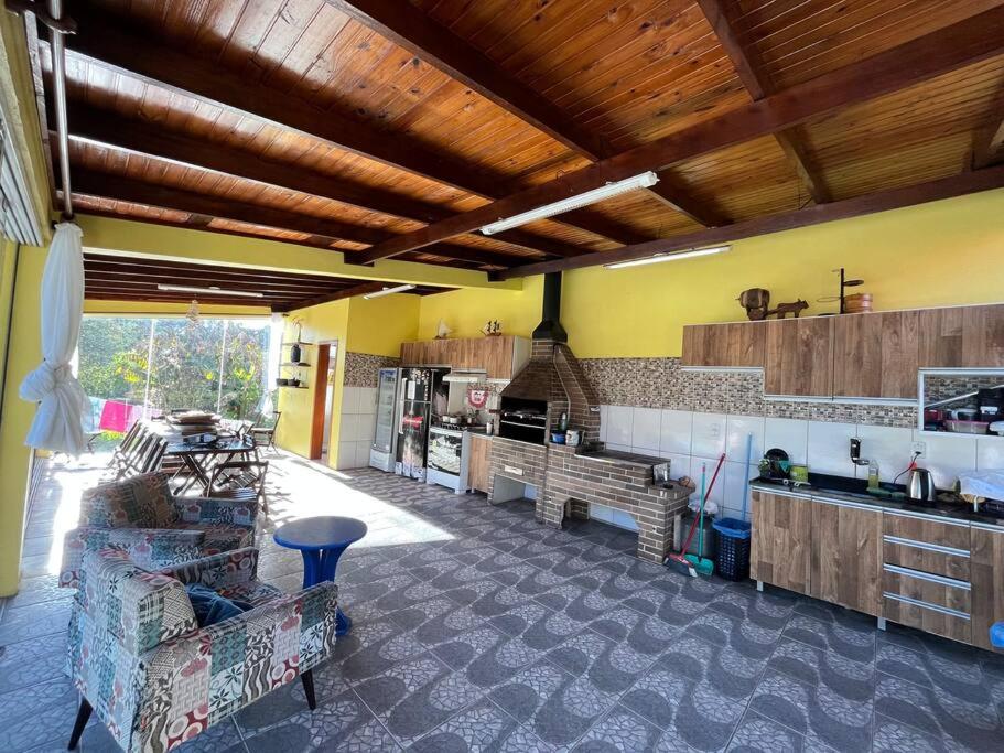 ein Wohnzimmer mit Couch und Küche in der Unterkunft Bem vindos a Vila da Paz Itaara in Itaara