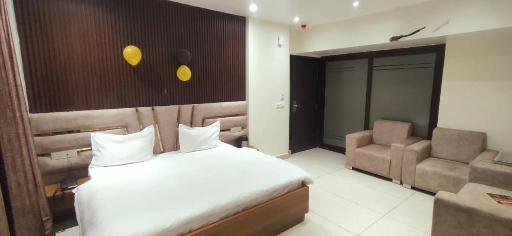 een hotelkamer met een bed en een stoel bij Green Valley Luxurious Hotel in Ghaziabad