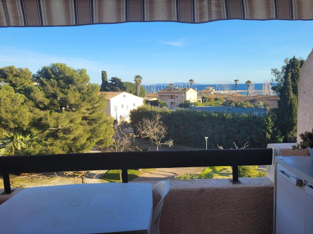 a white table on a balcony with a view at studio belle vue in La Londe-les-Maures