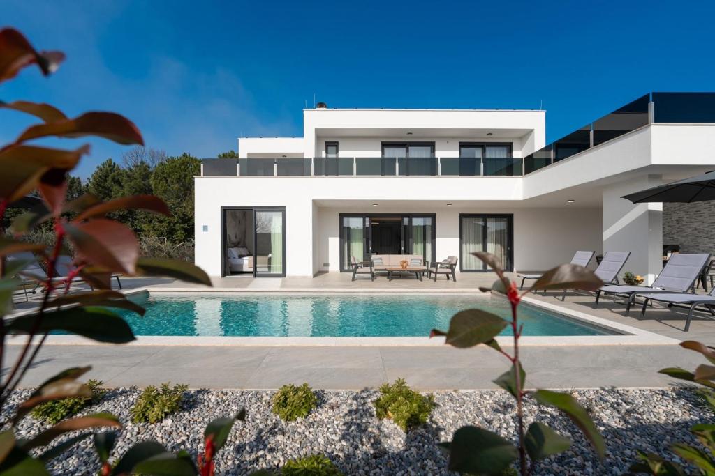 a house with a swimming pool in front of it at Villa Bella Ciao by SeeAdria Agency in Novigrad Istria