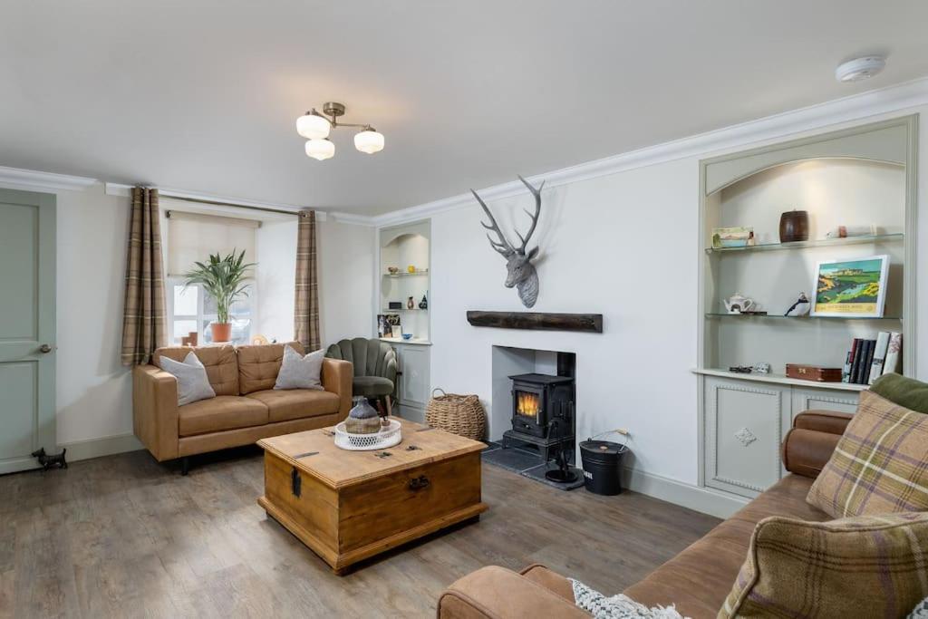a living room with a couch and a fireplace at The Tranquil Auchterarder 3-bed Cottage in Auchterarder