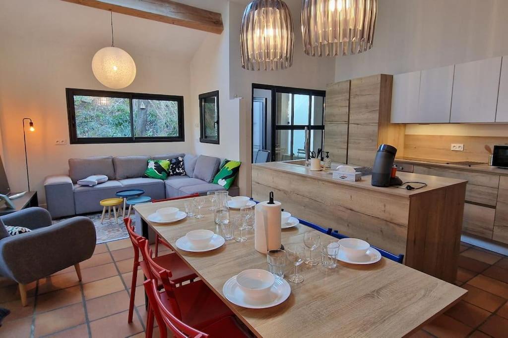 uma cozinha e uma sala de estar com mesa e cadeiras em La maison St Nicolas em Châteauneuf-du-Rhône