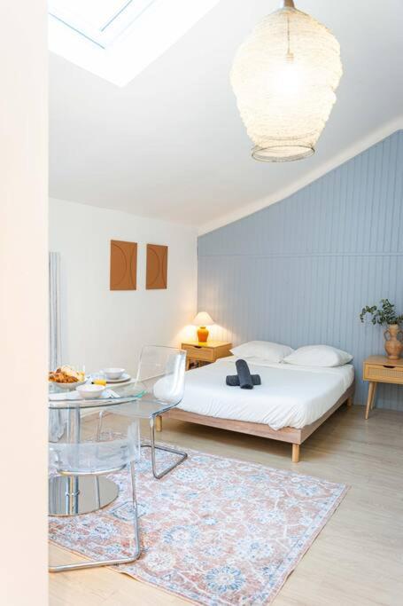 - une chambre avec un lit, une table et une table dans l'établissement Charmant Studio au cœur des Marais Salants, à Arles