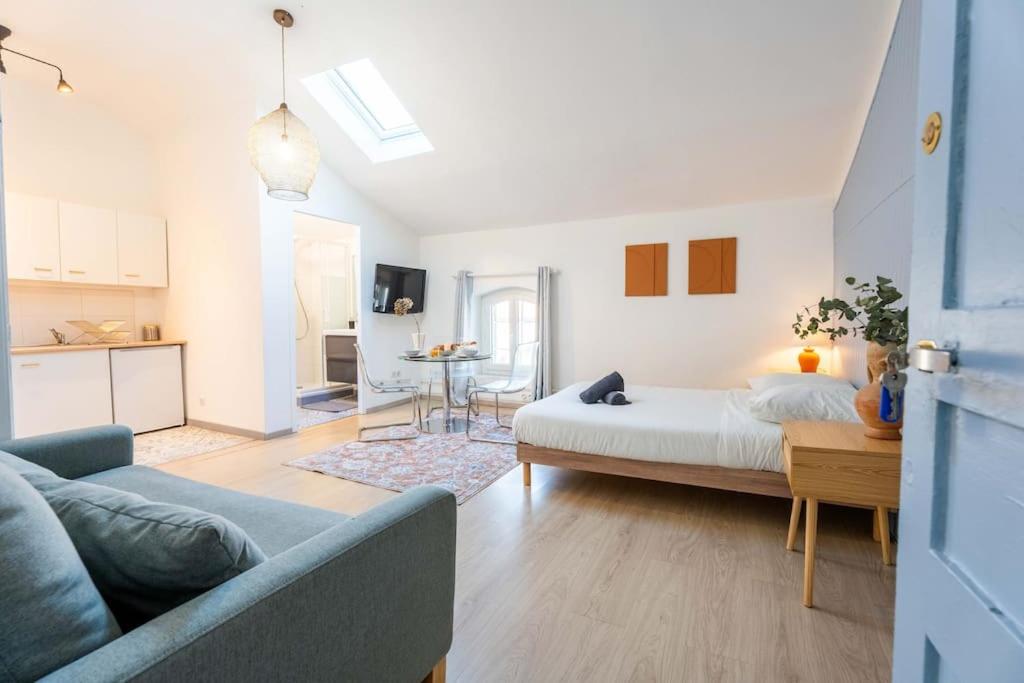 a bedroom with a bed and a living room at Charmant Studio au cœur des Marais Salants in Arles