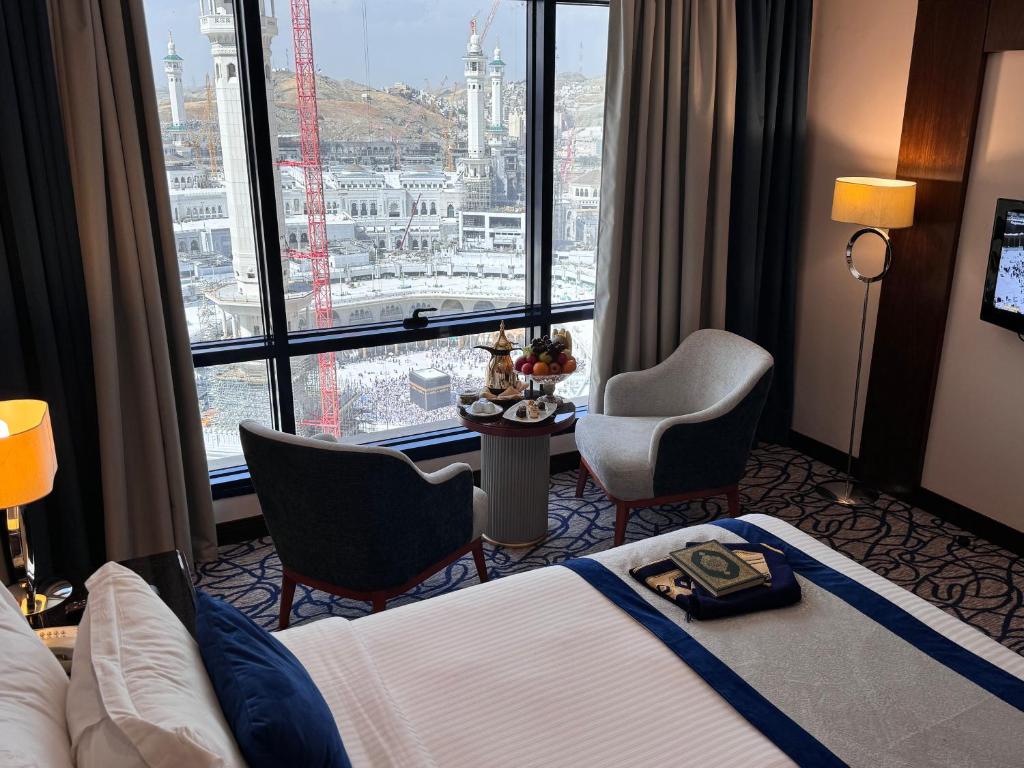 a hotel room with a bed and a large window at Al Safwah Hotel First Tower in Makkah