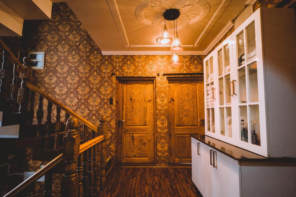 a hallway with a wooden door and a staircase at The Mallard by Evoke Hotels in Srinagar