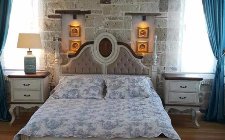 a bedroom with a large bed and two night stands at VİA PERLA BUTİK OTEL in Çiftlikköyü