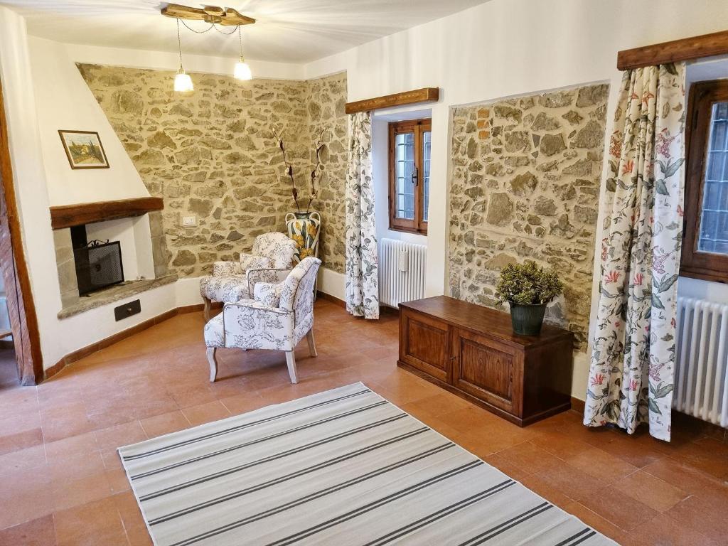 sala de estar con pared de piedra en Chianti Villa Chicco, piscina privata, ampio giardino, BBQ e parcheggio, en Lucolena in Chianti