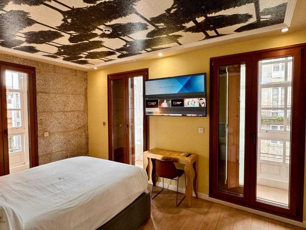 a bedroom with a bed and a tv on the ceiling at Casas Reais Boutique in Santiago de Compostela