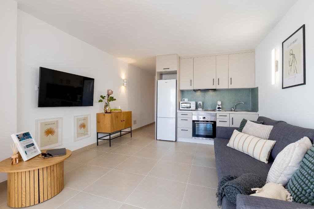 Una sala de estar con un sofá y una cocina. en Apartment in the heart of Fañabe area, en Adeje