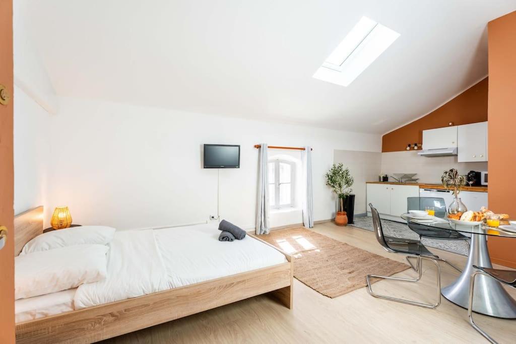 um quarto com uma cama, uma mesa e uma cozinha em Double Studio au coeur des Marais Salants em Arles
