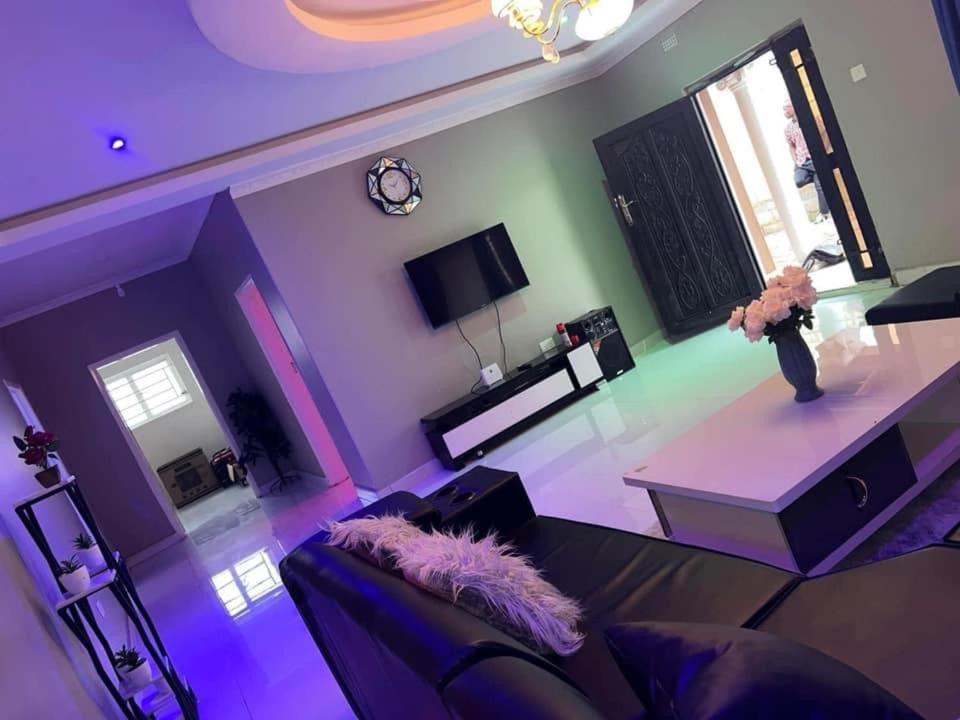 ein lila Wohnzimmer mit einem Sofa und einem Tisch in der Unterkunft Joydora apartments 3 in Lusaka