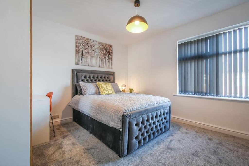 a bedroom with a large bed in a white room at Modern Home: Heart Of Blackburn in Blackburn