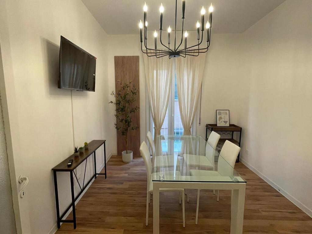 a dining room with a glass table and a chandelier at 'La Perla' nel centro di Frascati in Frascati