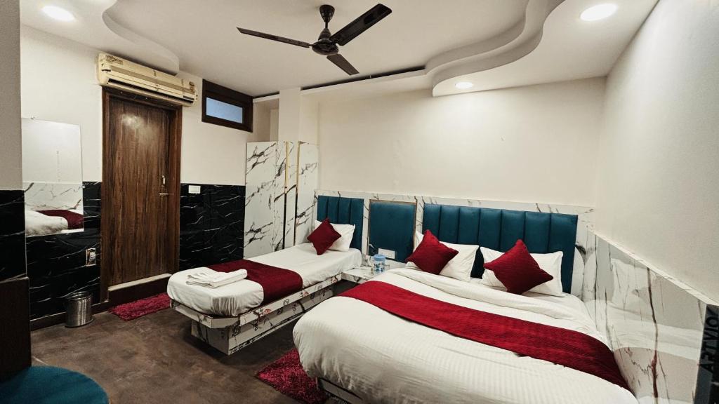 a bedroom with two beds and a ceiling fan at Hotel Vin Inn, Paharganj, New Delhi in New Delhi