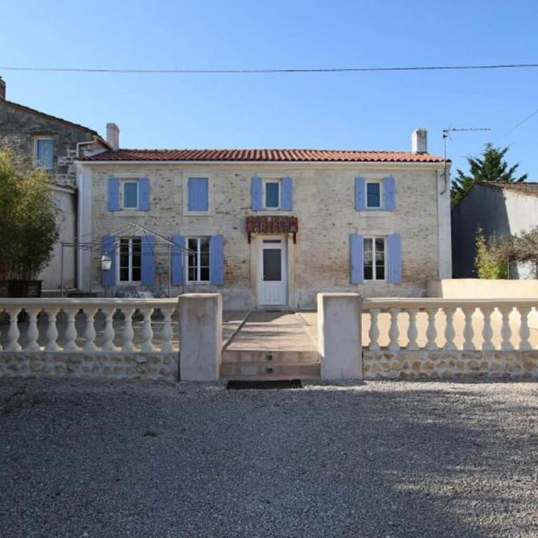 une maison en pierre avec une clôture blanche devant elle dans l'établissement Le domaine des 3 îles, à Romegoux