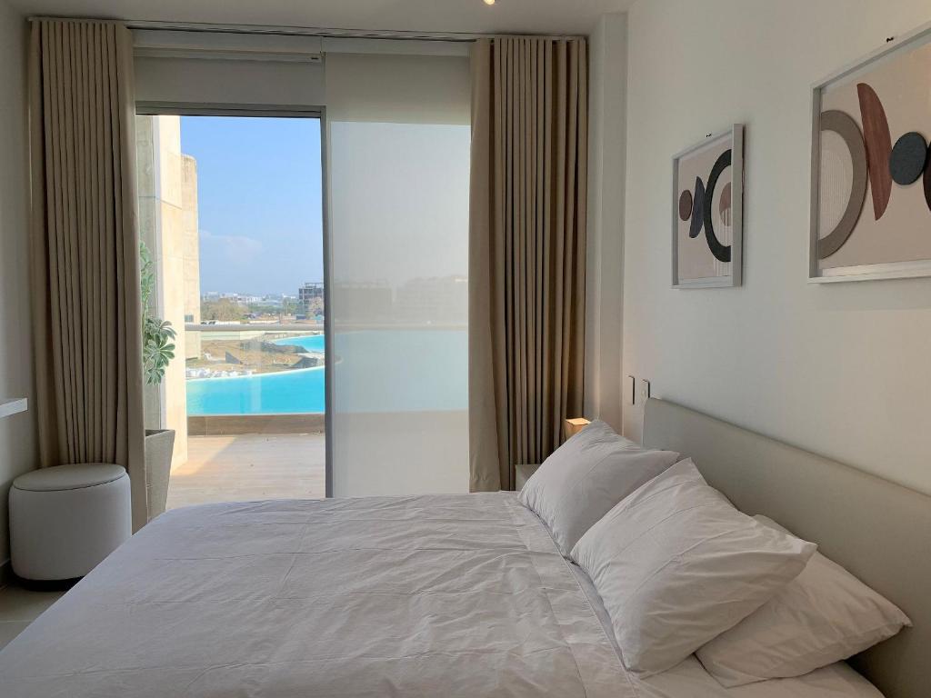 a bedroom with a bed and a view of a pool at Oasis Retreat - Cartagena in Los Arrayanes