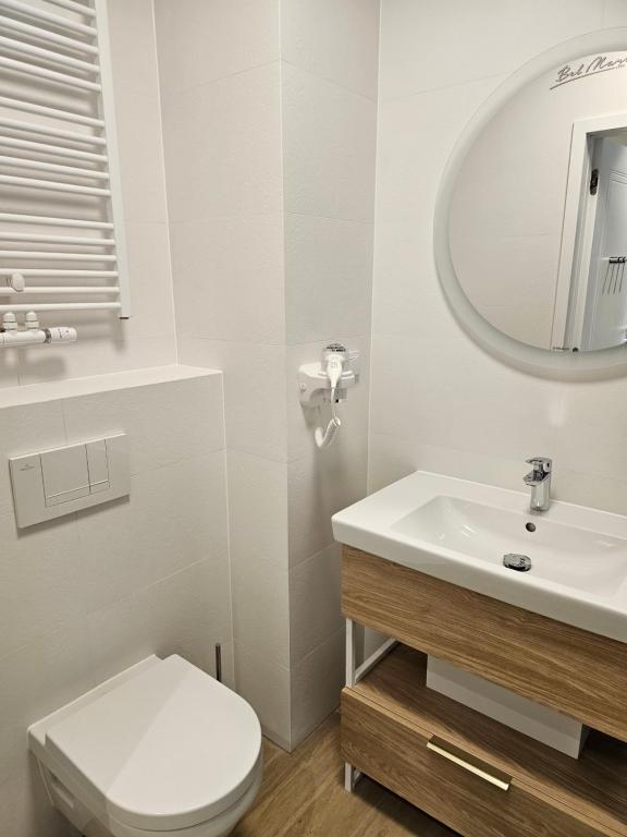 een witte badkamer met een toilet en een wastafel bij Ferienwohnung Ostseekult in Międzyzdroje