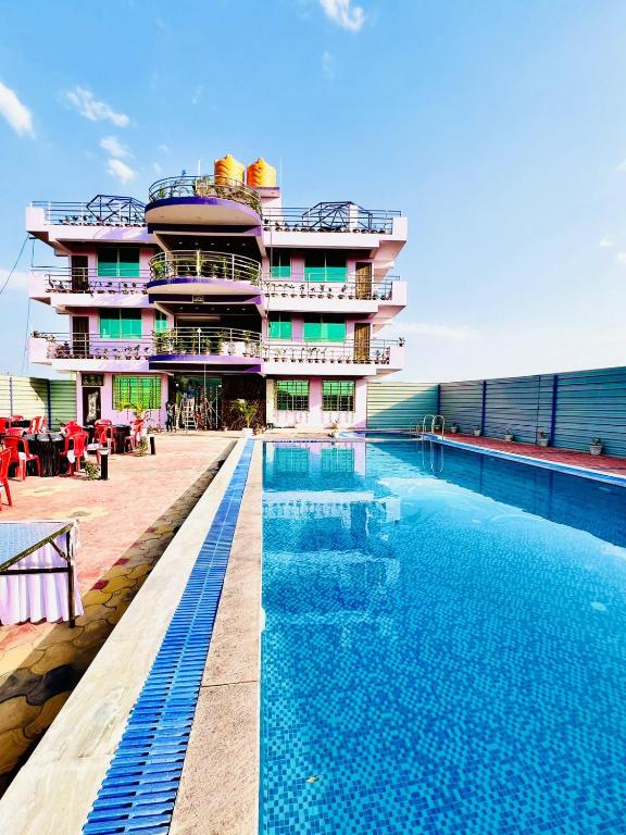a hotel with a swimming pool in front of a building at Roshan Resorts in Bhopal